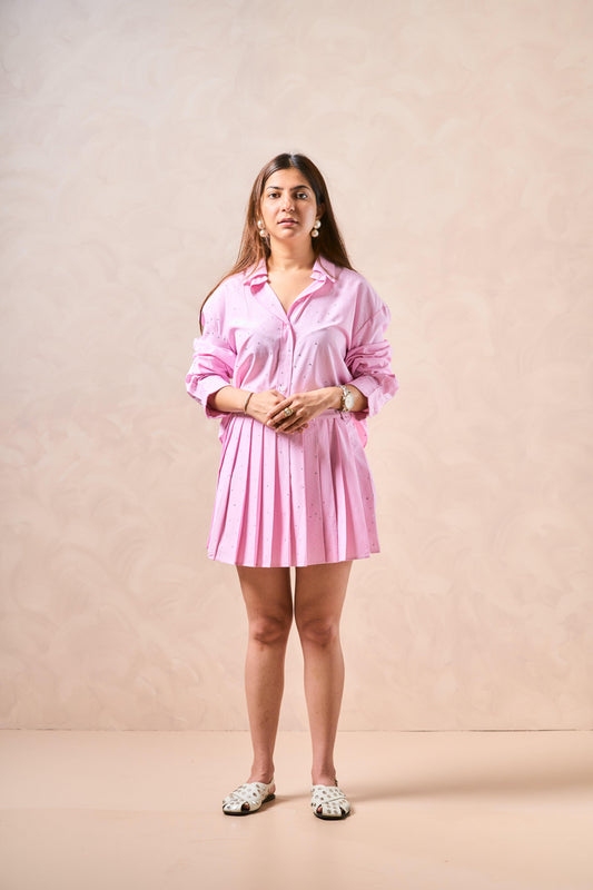 Woman wearing a pink dress against a beige background