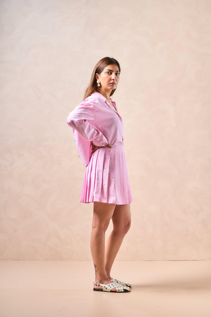 Woman wearing a pink dress against a beige background