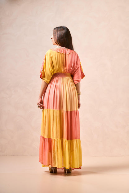 Woman wearing a colorful dress with a pink and yellow pattern against a beige background
