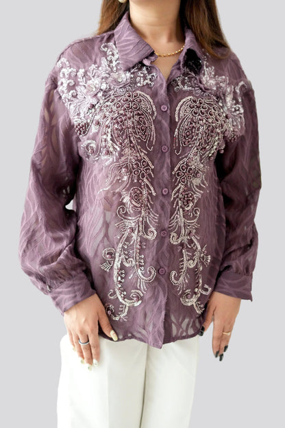 Purple embroidered shirt worn by a person on a plain background