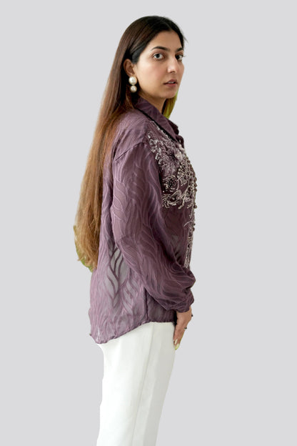 Woman wearing a purple embroidered shirt on a white background