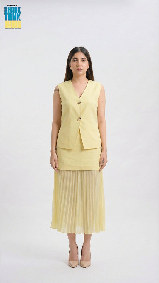 Woman wearing a yellow vest and pleated skirt on a white background