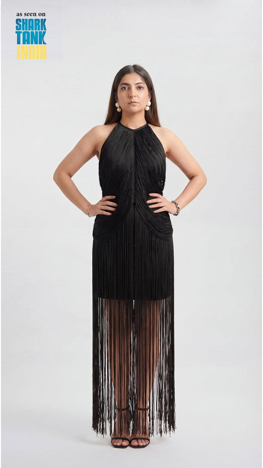 Woman wearing a black halter neck dress with fringe details on a white background