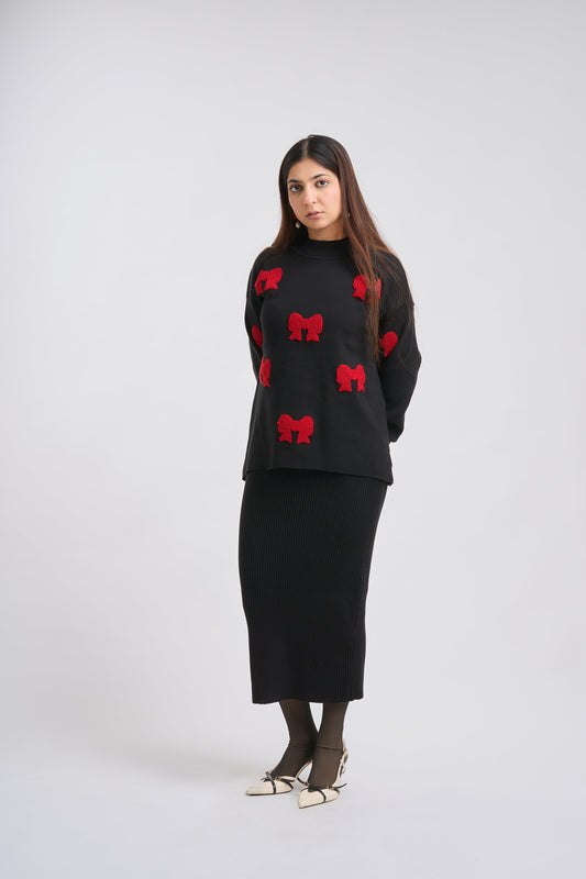 Woman wearing a black sweater with red patterns on a white background