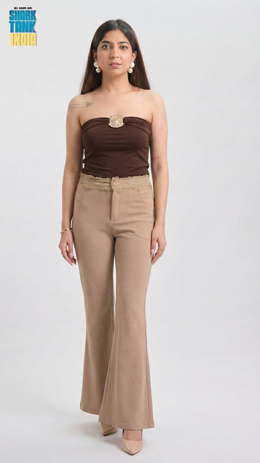 Woman wearing a brown strapless top and beige high-waisted pants on a white background