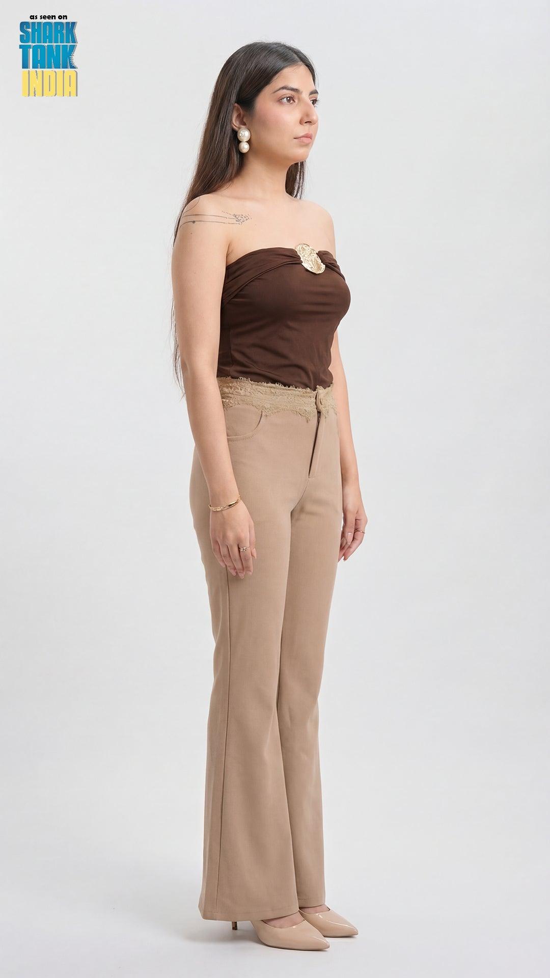 Woman wearing a brown strapless top and beige pants on a white background