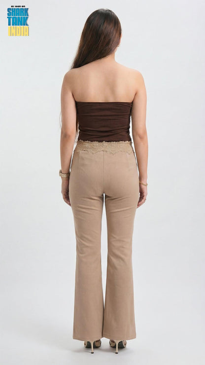 Woman wearing a strapless brown top and beige flared pants on a white background
