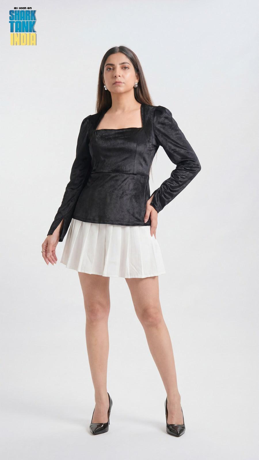 Woman wearing a black top and white skirt on a white background