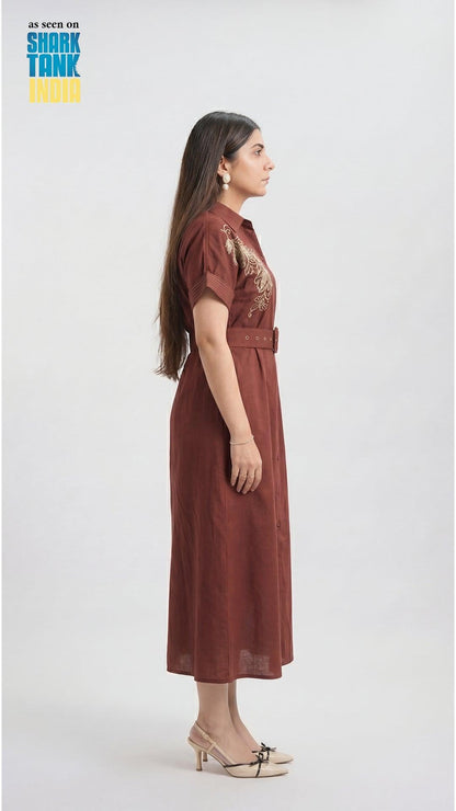 Woman wearing a brown dress with a belt on a white background, featuring 'Shark Tank' branding.