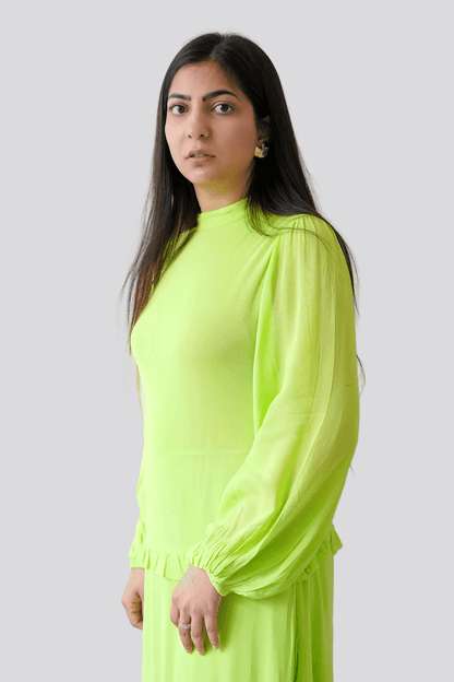 Woman wearing a bright green dress against a plain background
