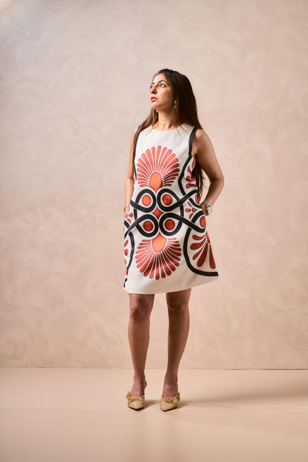 Woman wearing a sleeveless dress with a geometric pattern on a beige background