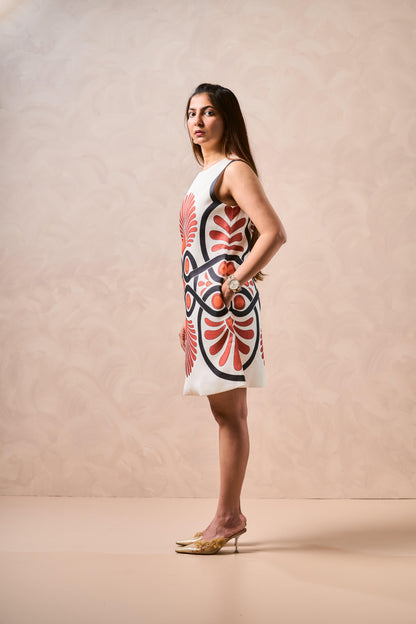 Woman wearing a white dress with red and black floral pattern on a beige background