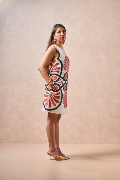 Woman wearing a sleeveless dress with a red and black pattern on a beige background