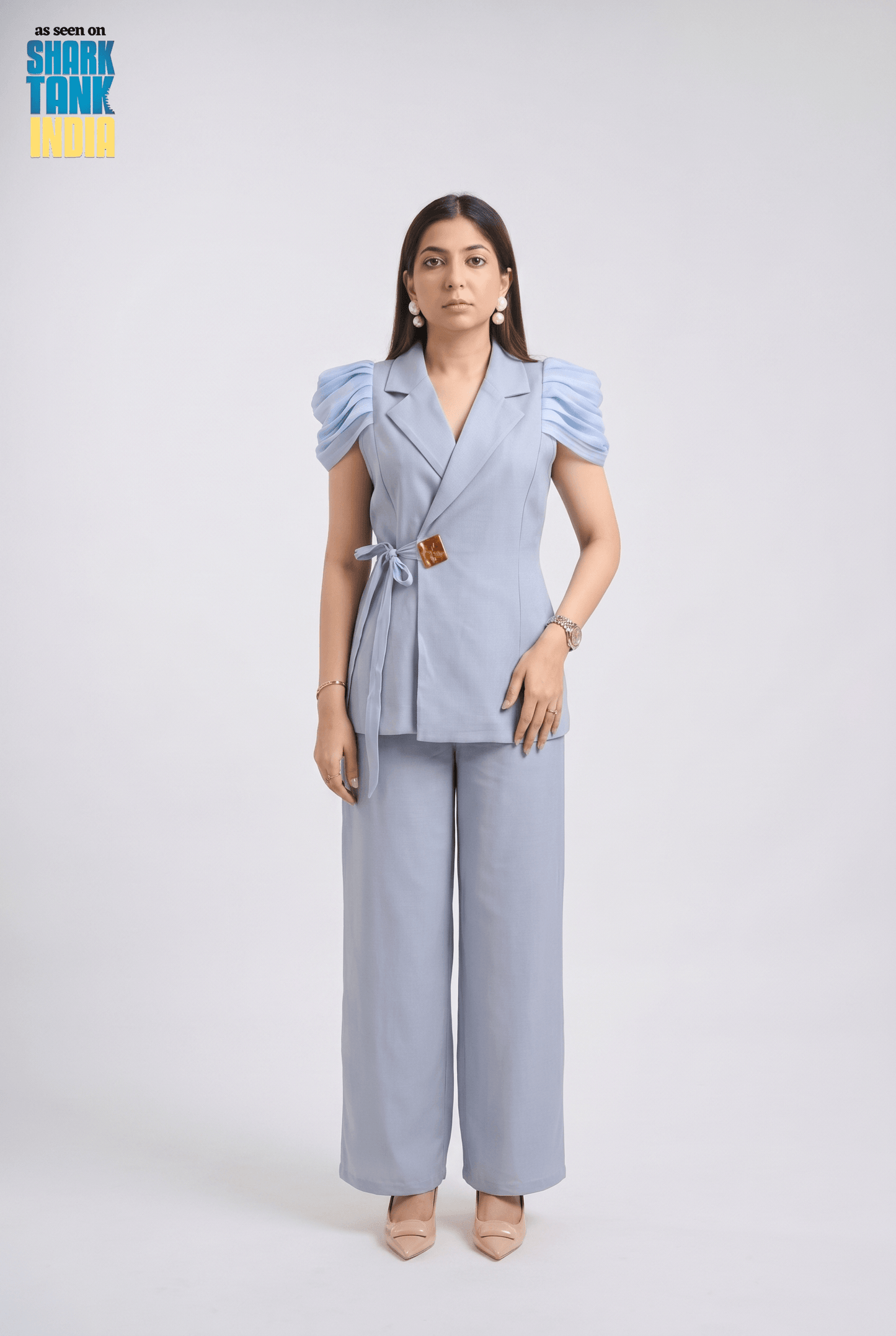 Woman wearing a light blue outfit with puffed sleeves on a white background