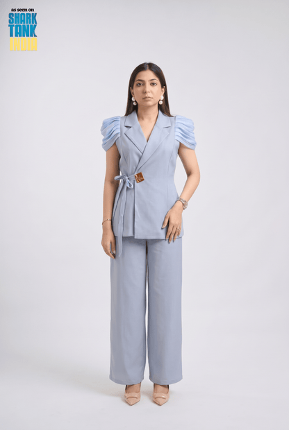 Woman wearing a light blue outfit with puffed sleeves on a white background