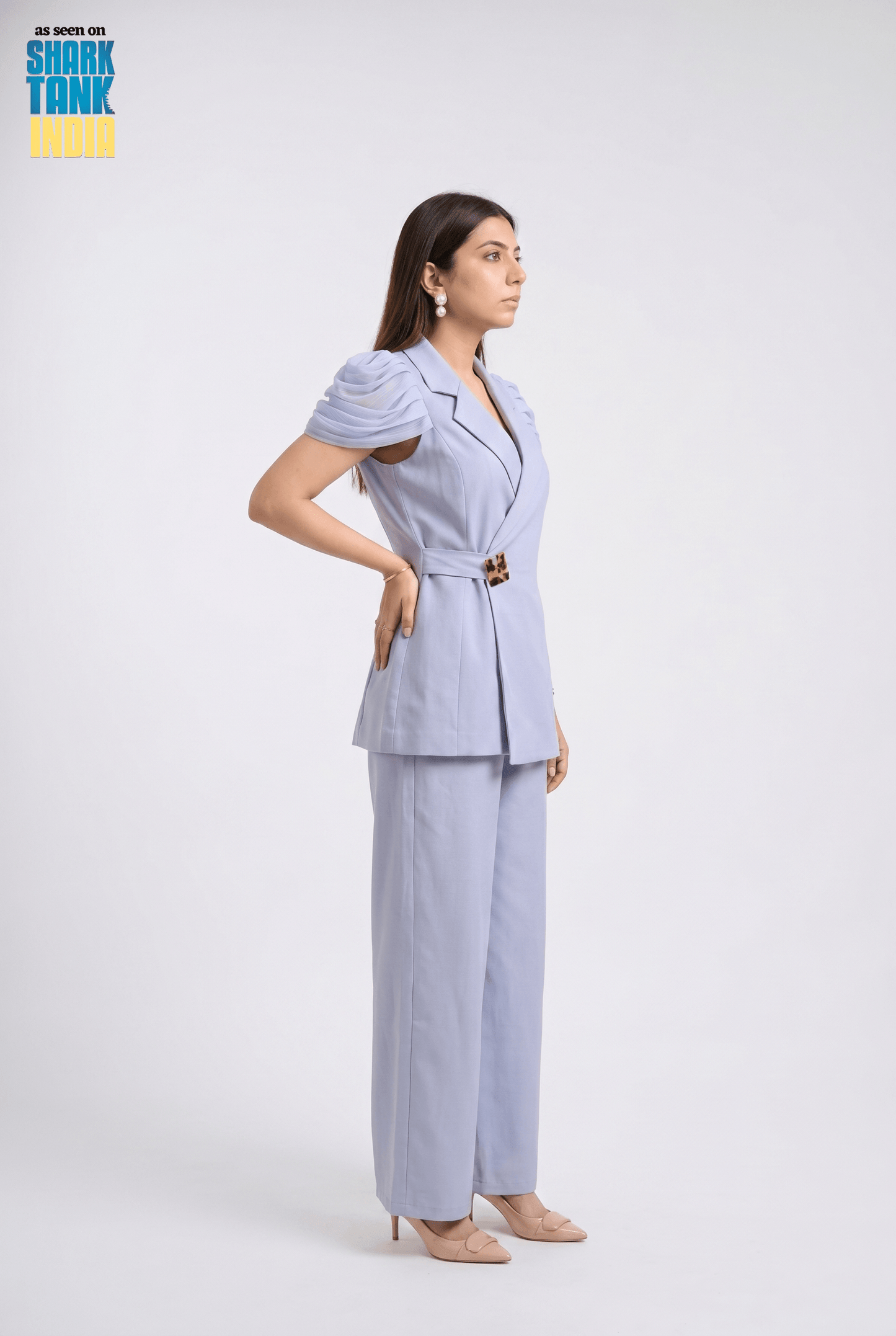 Woman wearing a light blue suit with 'Shark Tank' branding in the corner.