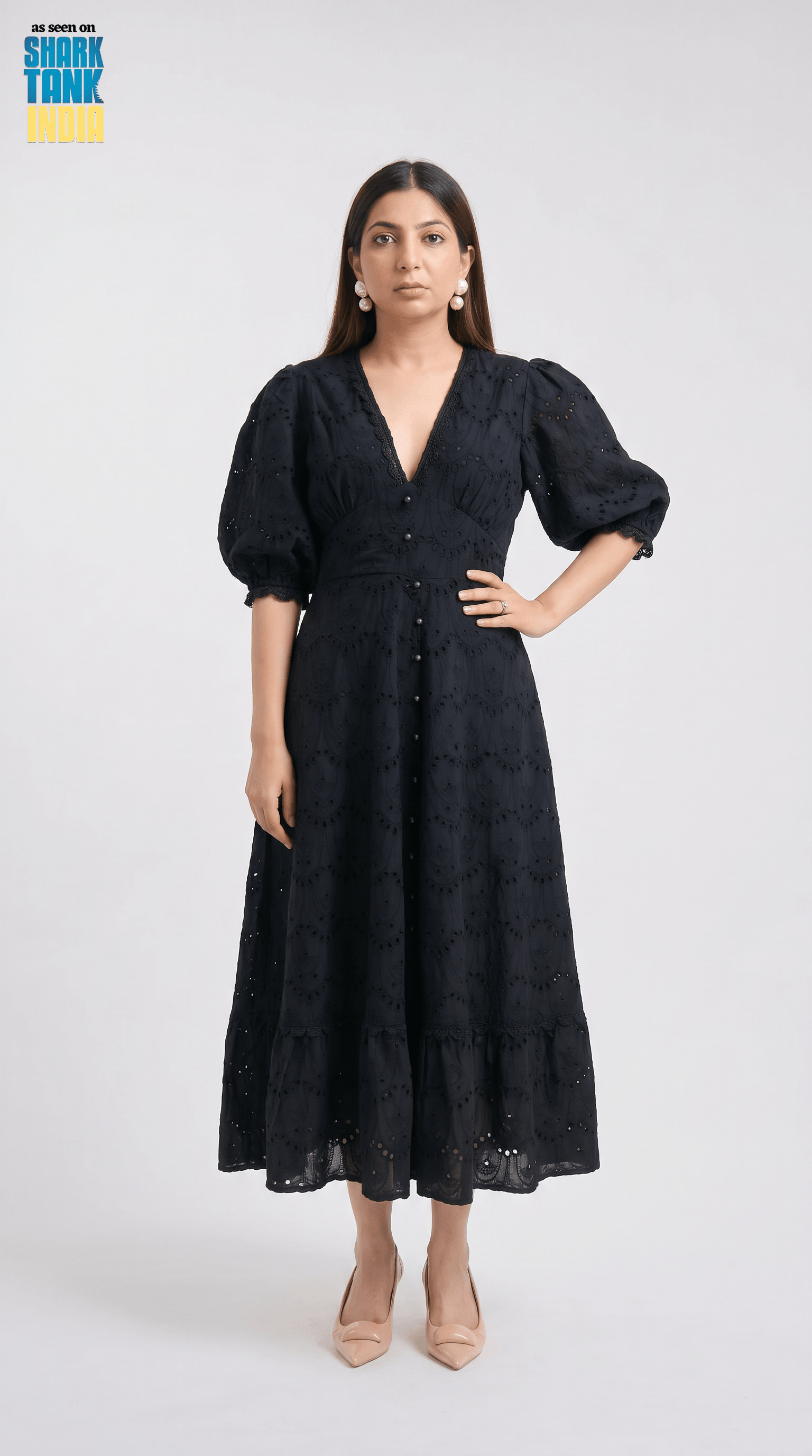 Woman wearing a black dress with puffed sleeves on a white background