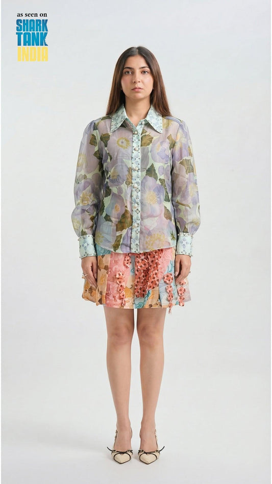 Woman wearing a floral shirt and skirt on a white background with 'Shark Tank' branding.