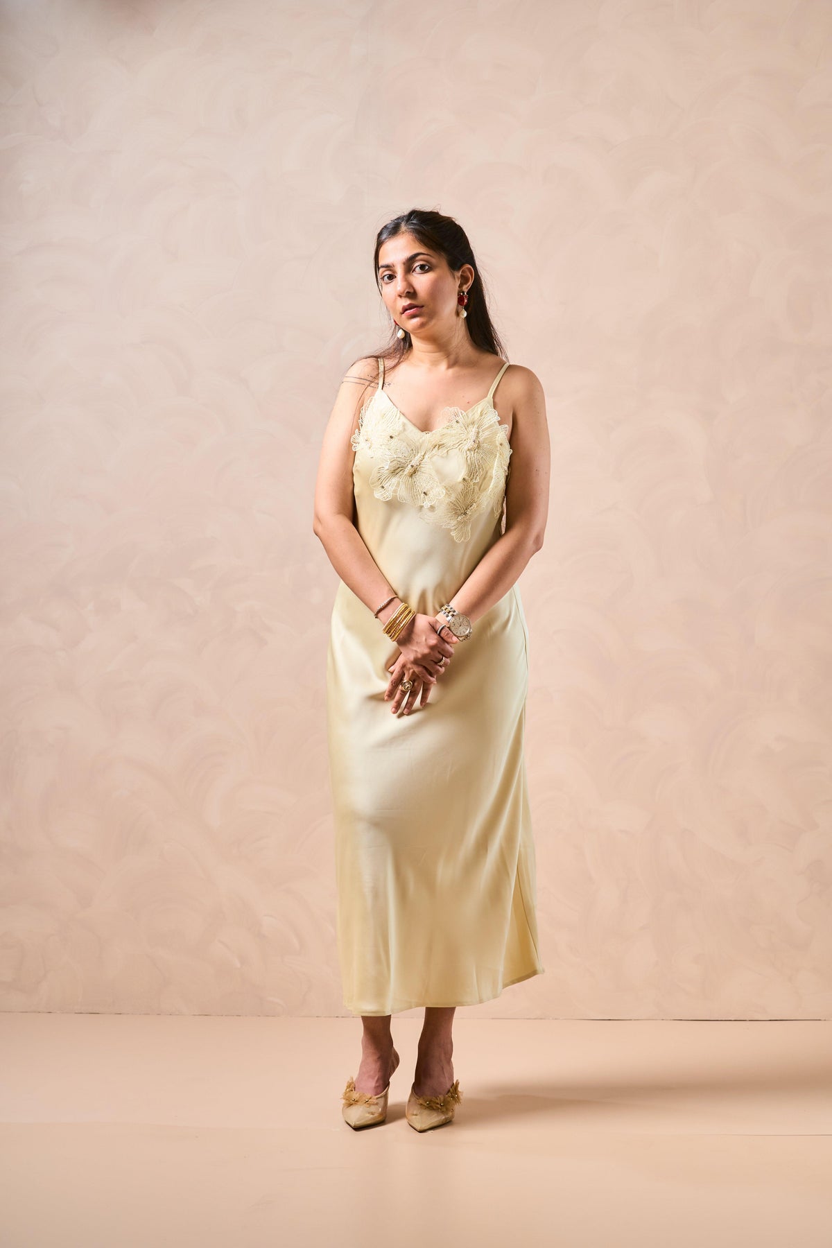 Woman wearing a light-colored dress against a beige background