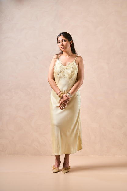 Woman wearing a light-colored dress against a beige background