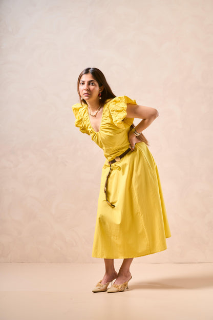 Woman wearing a yellow dress against a beige background
