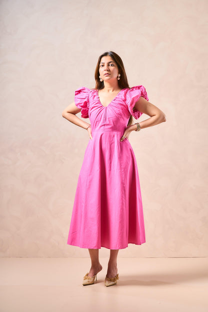 Woman wearing a pink dress against a beige background