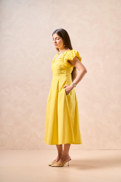 Woman wearing a yellow dress against a beige background