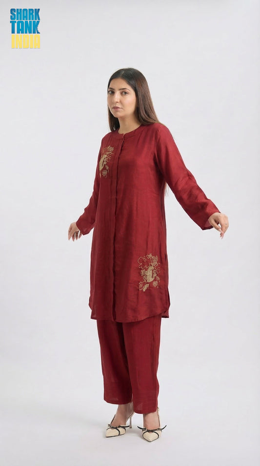 Woman wearing a red traditional outfit with gold embroidery on a white background