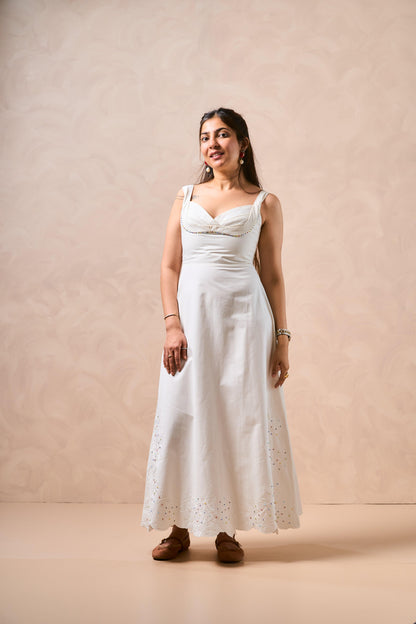 Woman wearing a white dress against a beige background