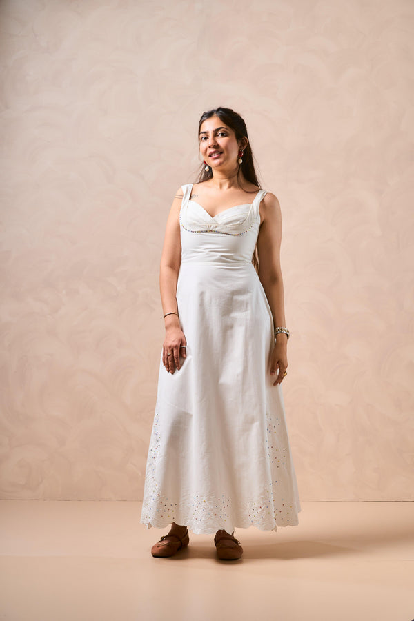 Woman wearing a white dress against a beige background