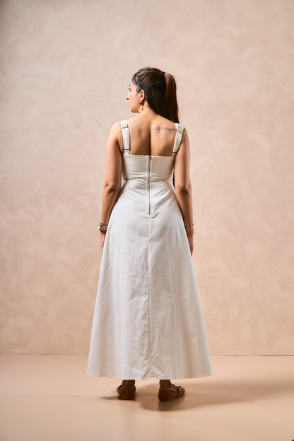 Woman wearing a white dress with thin straps against a beige background