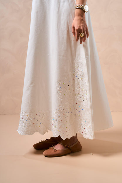 White lace dress with brown shoes on a beige background