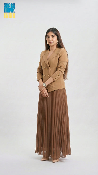 Woman wearing a brown blazer and pleated skirt on a white background