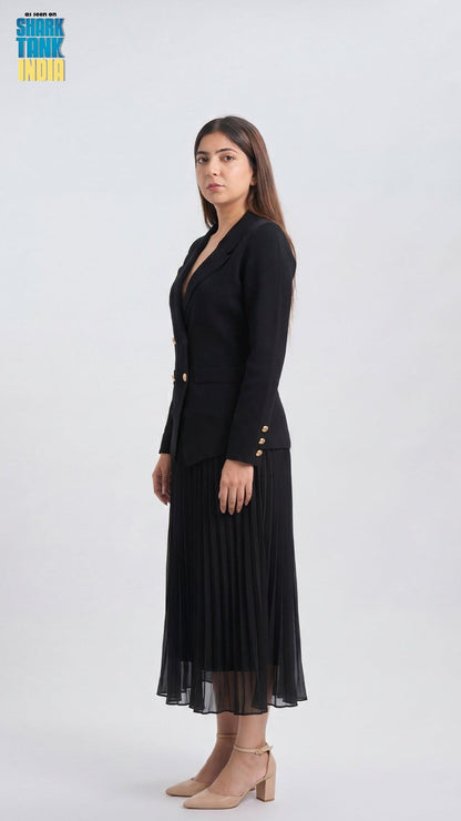 Woman wearing a black blazer and pleated skirt on a white background