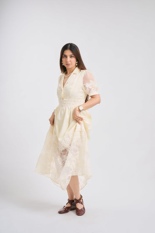 Woman wearing a light-colored dress with lace details on a white background