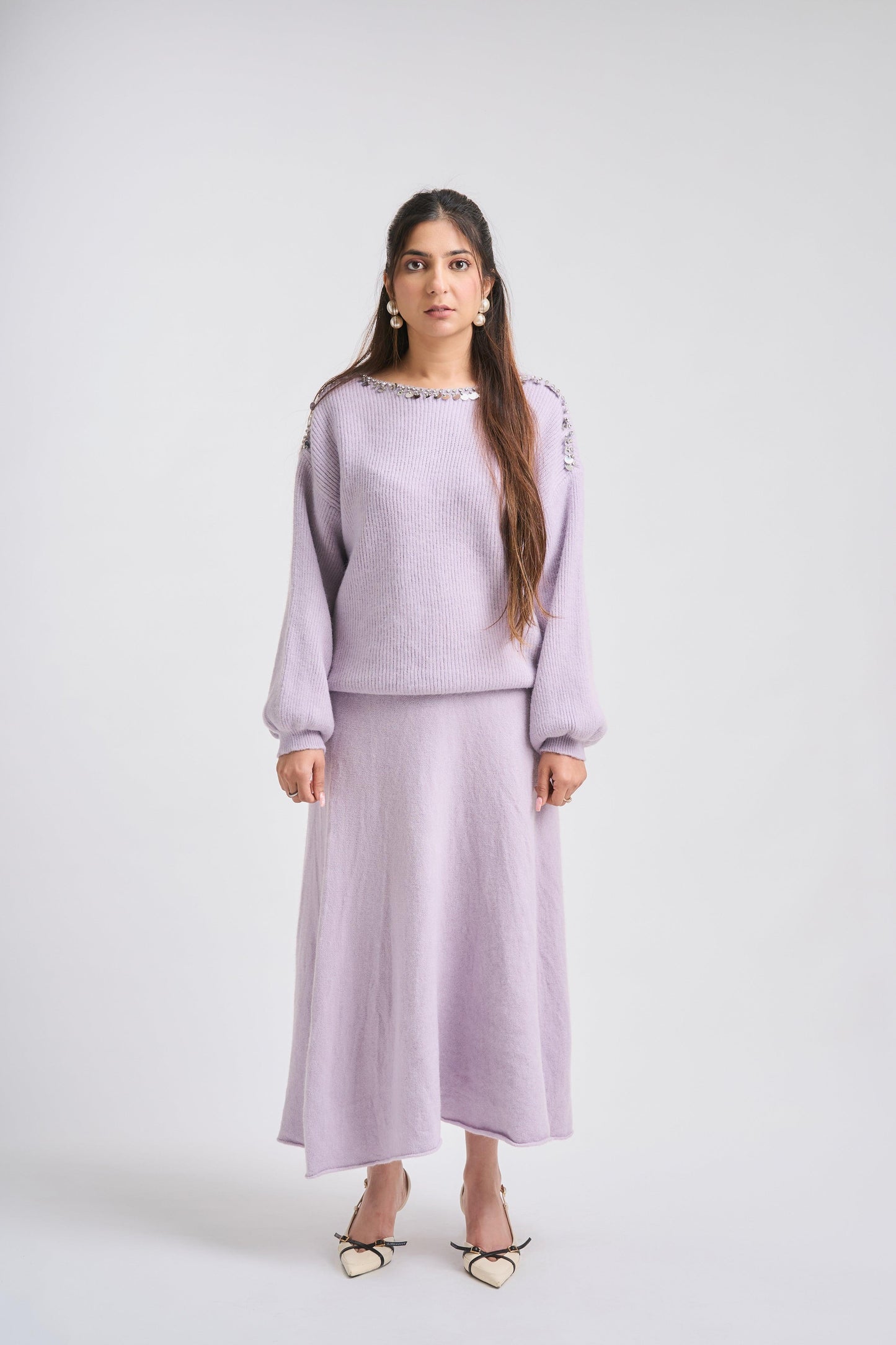 Woman wearing a light purple outfit on a white background