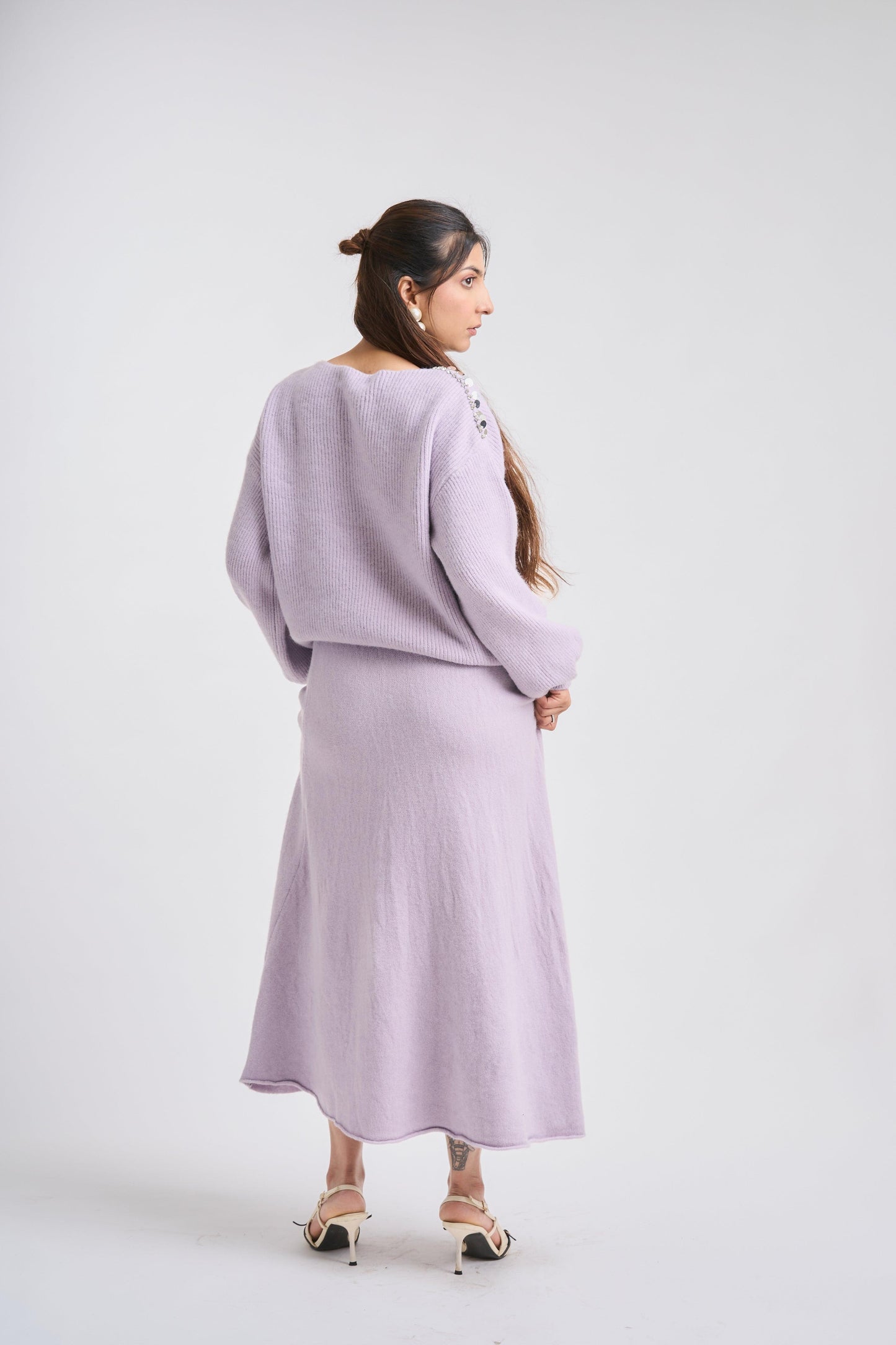 Woman wearing a light purple outfit on a white background