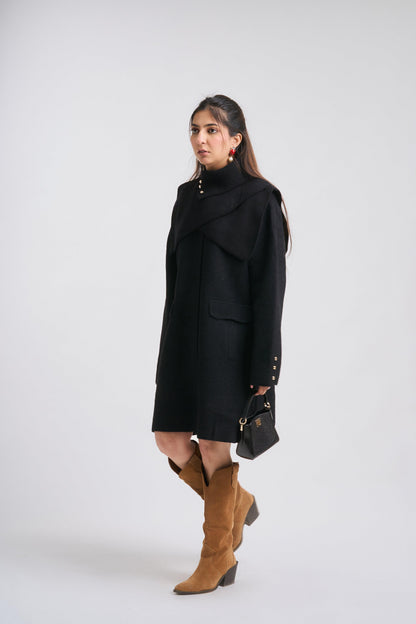 Woman wearing a black coat and brown boots on a white background