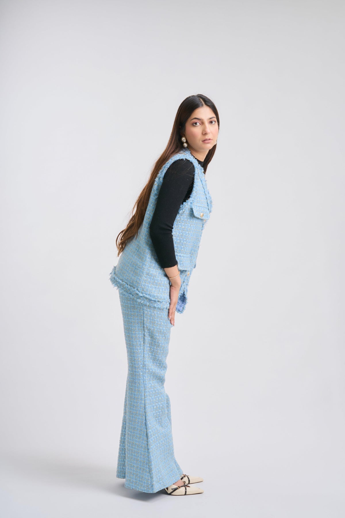 Woman wearing a blue checkered outfit on a white background