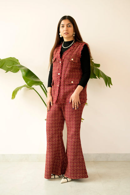 Woman wearing a red checkered outfit with a vest indoors.