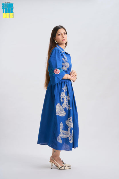 Woman wearing a blue embroidered dress on a white background