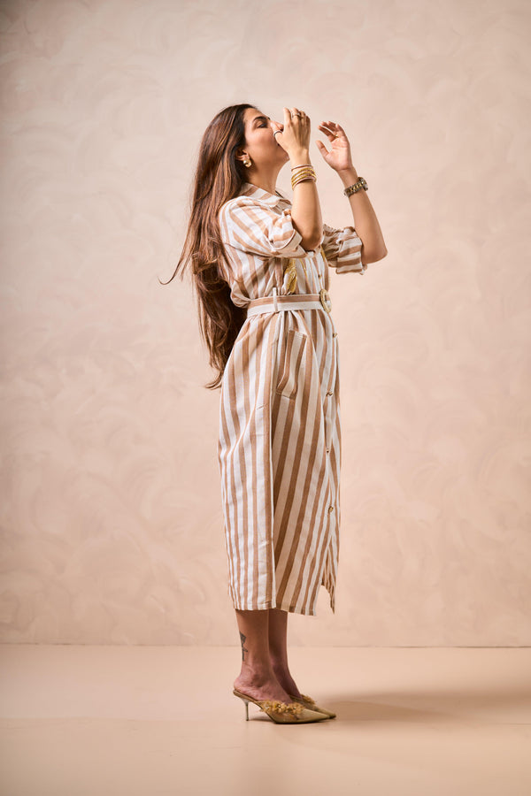 Woman wearing a striped dress against a beige background