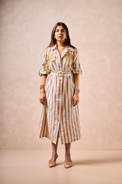 Woman wearing a striped dress with a belt against a beige background