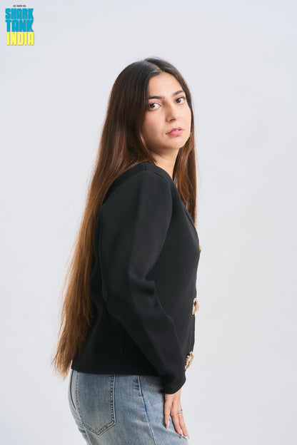 Woman wearing a black sweater and blue jeans against a white background