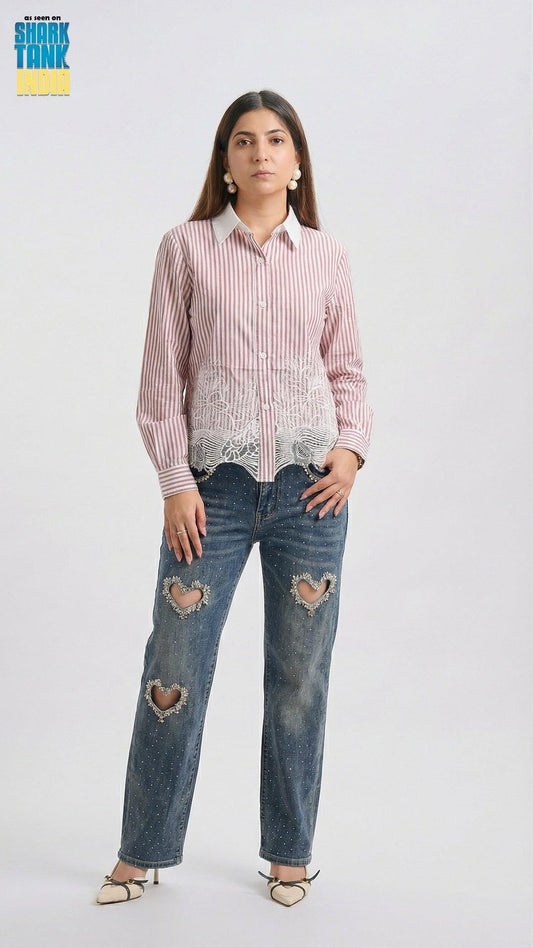 Woman wearing a red and white striped shirt with lace detailing and blue jeans with heart cutouts on a white background.