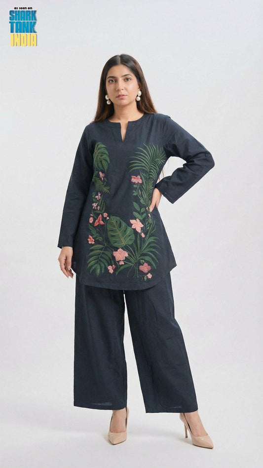 Woman wearing a dark blue outfit with floral embroidery on a white background