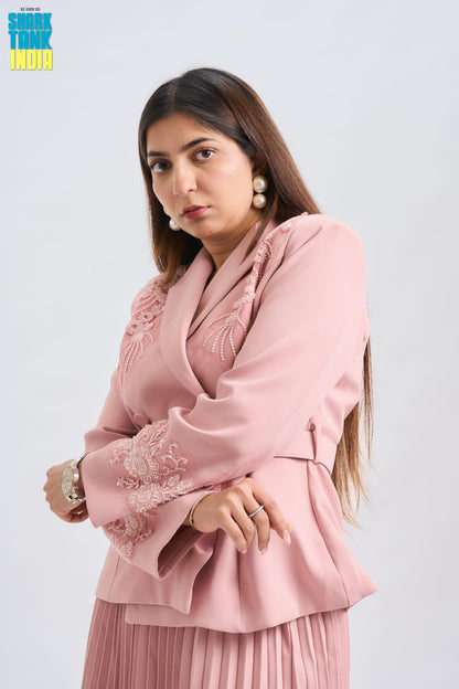 Woman wearing a pink outfit with lace details on a white background