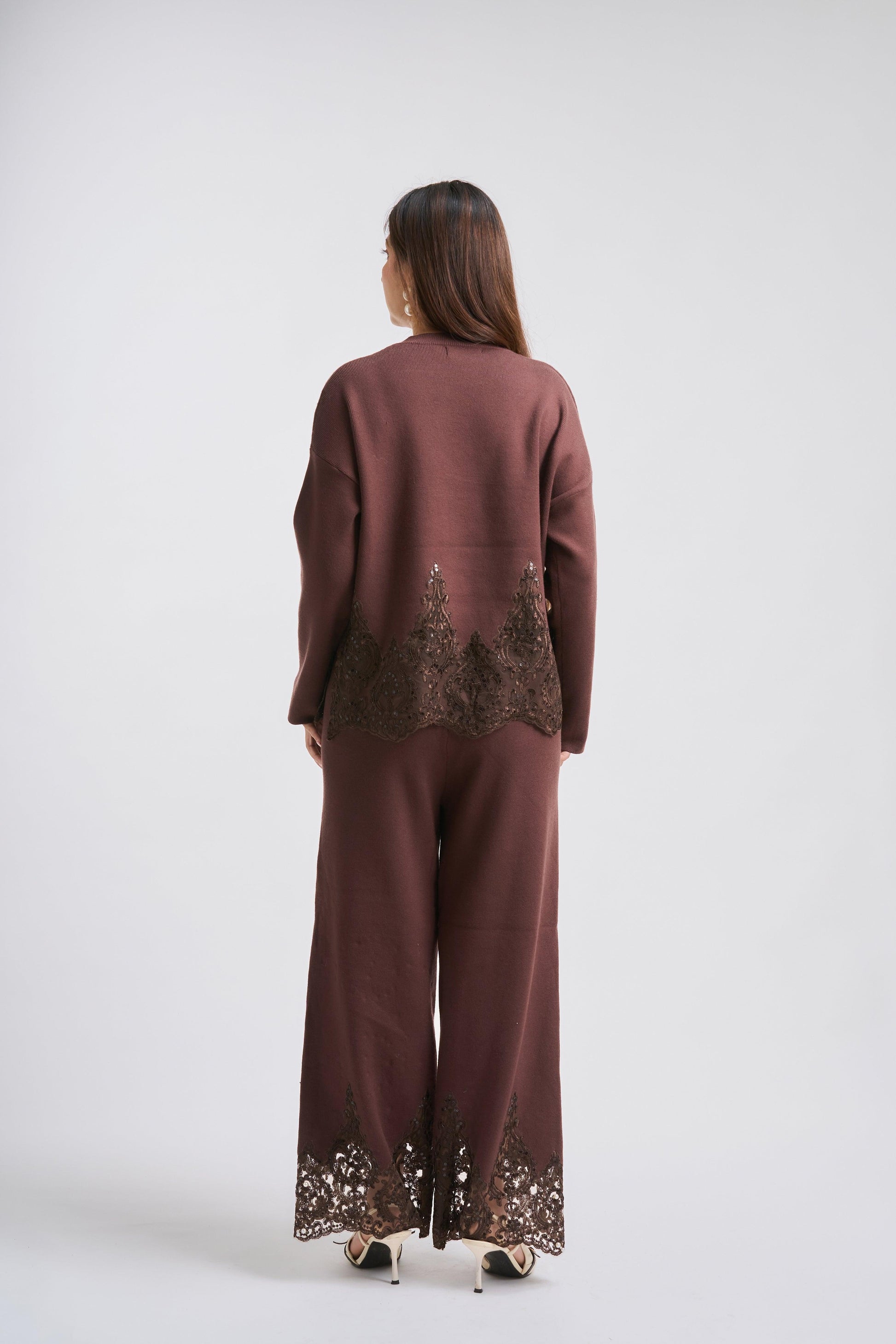 Woman wearing a brown outfit with lace details on a white background