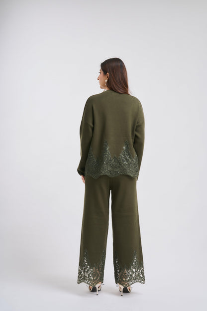 Woman wearing a green outfit with sequin details on a white background