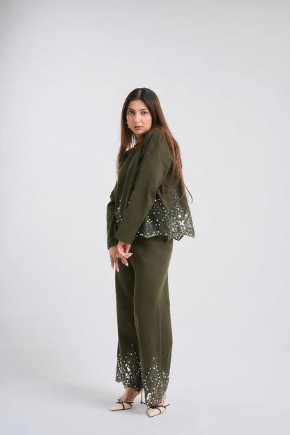 Woman wearing a green outfit with sequin details on a white background